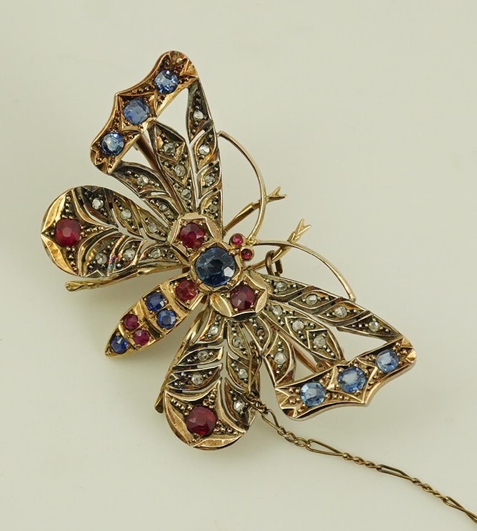 An Edwardian gold, ruby, sapphire and rose cut diamond set butterfly brooch